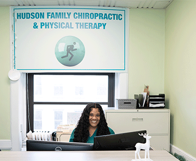 Female Receptionist sitting behind a desk at Hudson Family Chiropractic in Hoboken, NJ